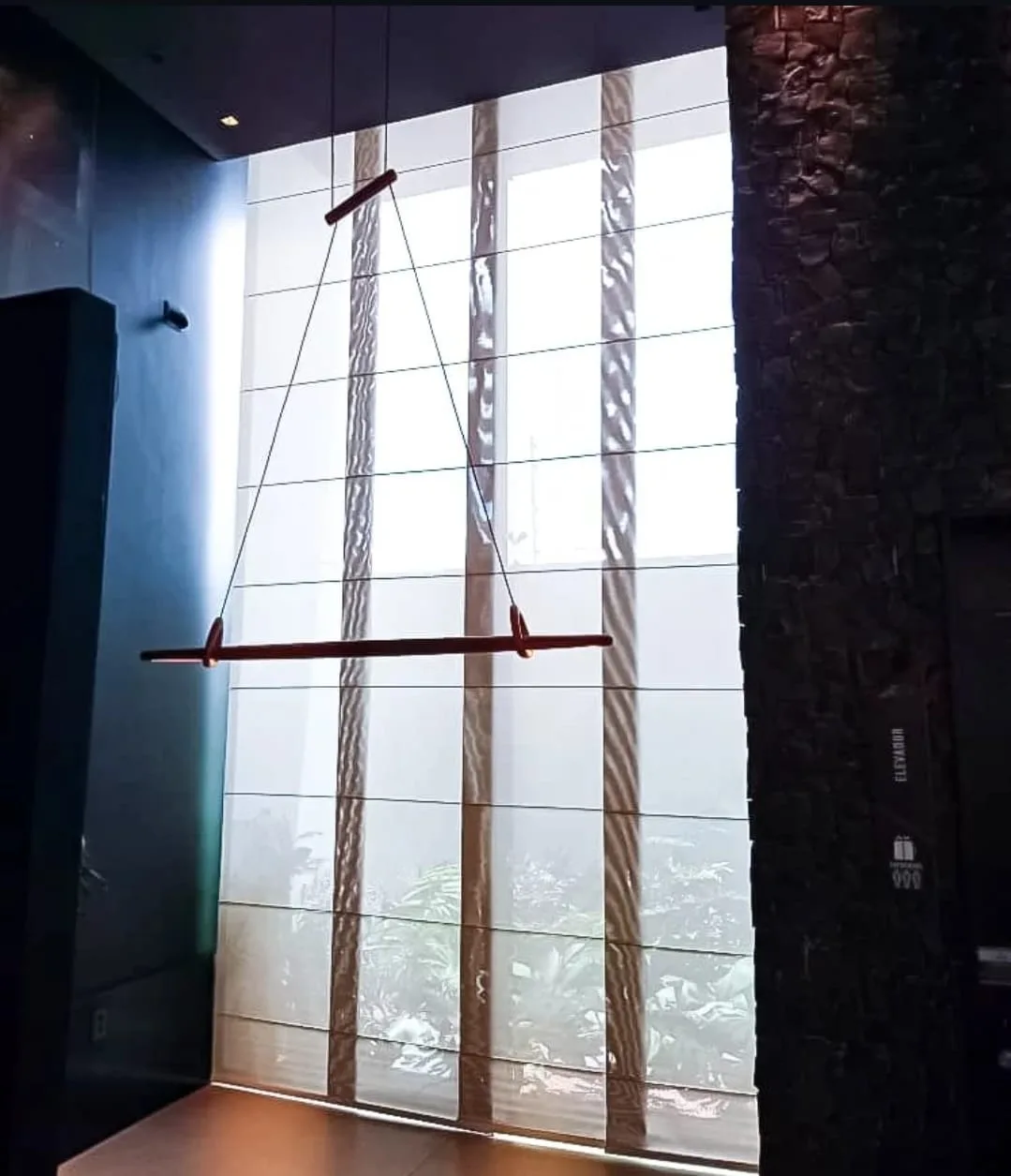 Cortina painel em vidro de pé-direito duplo em ambiente comercial