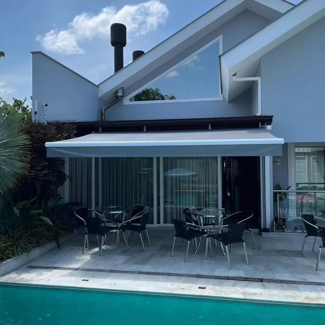 Toldo vermelho cobrindo área gourmet com churrasqueira