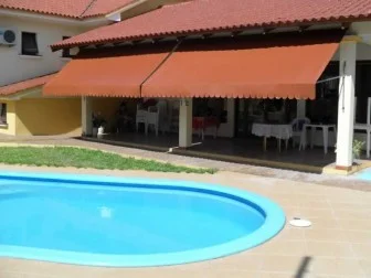 Toldos retráteis terracota cobrindo área de piscina